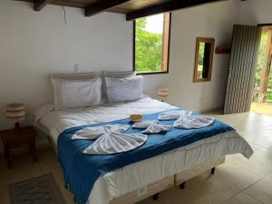 a bedroom with a bed with towels on it at POUSADA PÔR DO SOL in Ipiabas