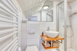 诺德奈AchterHuus的浴室配有洗手池和淋浴 更多16张照片