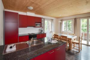 a kitchen with red cabinets and a dining table at CityChalet in Interlaken