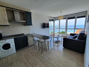 een keuken en een woonkamer met een bank en een tafel bij Apartamentos Rozas Vellas in Sanxenxo