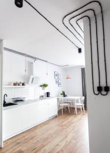 a kitchen and dining room with white cabinets and a table at Check in Szczecin in Szczecin +6 photos