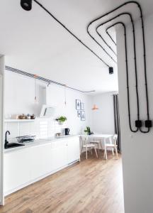 a kitchen and dining room with white cabinets and a table at Check in Szczecin in Szczecin