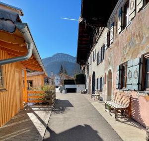 eine Straße mit einer Bank zwischen zwei Gebäuden in der Unterkunft FeWo Lebensfreude in Mittenwald