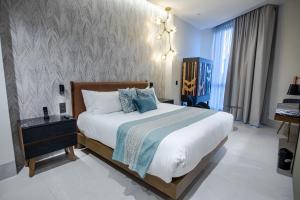 a bedroom with a large bed and a wall at Becquer Hotel Guadalajara in Guadalajara
