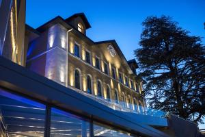 un bâtiment avec une horloge sur son côté dans l'établissement Le Pélican, à Annecy