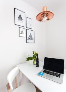 a white desk with a laptop and a lamp at Check in Szczecin in Szczecin