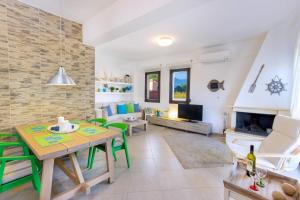a living room with a table and chairs and a fireplace at Ekavi Villa in Skala Potamias