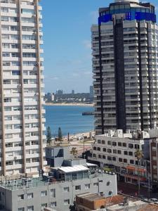 uitzicht op een stad met hoge gebouwen en de oceaan bij Santos Dumont 805 in Punta del Este