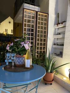 a blue table with a bottle of wine and some plants at Arco di Levante in Bari