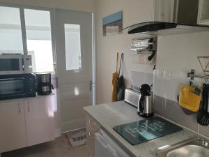 a small kitchen with a sink and a microwave at le Home Sweet Home d'Alice!!! à la Villa Alice Roger in Dunkerque