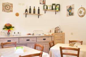 a kitchen with two tables and a counter with wine bottles at Agriturismo Karrares in Melendugno +34 photos
