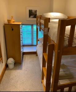 a bedroom with two bunk beds and a window at Church Gate Cottage - Bridestowe in Bridestowe