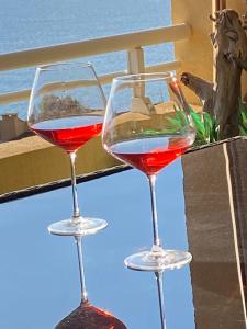 AJACCIO Très beau T2 confortable Sanguinaires في أجاكسيو: كأسين من النبيذ الأحمر والأبيض جالسين على طاولة