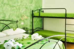 a bedroom with two bunk beds with green walls at Agriturismo Karrares in Melendugno