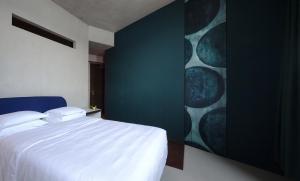 a bedroom with a blue wall and a blue bed at Hotel Locanda del Benaco in Salò