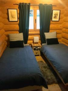 1 dormitorio con 2 camas y ventana en Chalet Les Pins Blancs en Allos