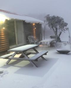 a picnic table in the snow in front of a house at צימר סאפי in Nimrod