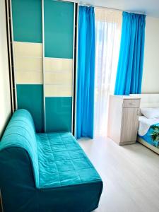 a bedroom with a blue bed and blue curtains at More Udachi Gostevoy Dvor in Kabardinka