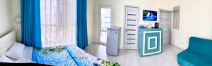カバルジンカにあるMore Udachi Gostevoy Dvorのベッドルーム1室(青いカーテン、ベッド1台、窓付)