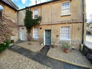 a brick house with a blue door and some plants at Chapel Cottage Idylic Village Holiday Home in Box