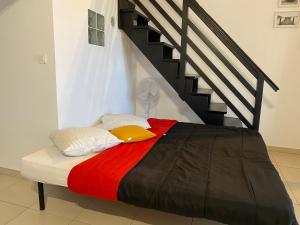uma cama com um cobertor vermelho e uma escada em U-Casone em Linguizzetta