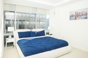 ein weißes Schlafzimmer mit einem großen Bett mit blauer Bettwäsche in der Unterkunft Arlington 2BR 2Ba Fully Furnished Apartment in Crystal City apts in Arlington