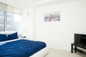 a bedroom with a blue bed and a tv at Arlington 2BR 2Ba Fully Furnished Apartment in Crystal City apts in Arlington +18 photos