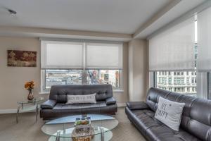 a living room with two leather couches and a table at Fully Furnished 2 Bedroom Apartment in Washington DC apts in Washington, D.C.