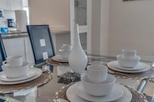 una mesa de cristal con platos y tazas y un jarrón en Fully Furnished 2 Bedroom Apartment in Washington DC apts, en Washington