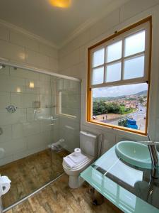 a bathroom with a toilet and a sink and a window at Pousada Imperial Cidade in Ouro Preto