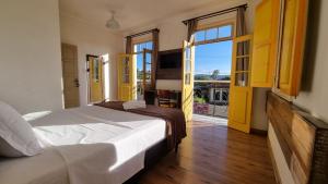a bedroom with a bed and a large window at Pousada Imperial Cidade in Ouro Preto