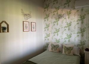 1 dormitorio con 1 cama con mariposas en la pared en Vuelos de Montaña l, en Montánchez