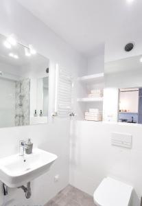 een witte badkamer met een wastafel en een toilet bij Check in Szczecin in Szczecin