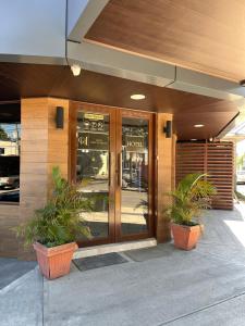 a building with two potted plants in front of a door at Hotel Guest House Inn in San Pedro Sula