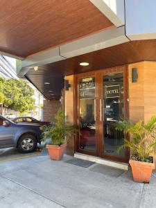 un hotel con plantas frente a un edificio en Hotel Guest House Inn en San Pedro Sula