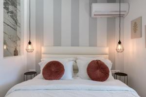 a bedroom with a bed with two pillows on it at Stylish Voula Apartment with pool close to Kavouri Beach in Athens