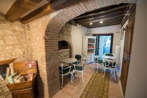 uma sala de estar com uma lareira de tijolos e uma mesa e cadeiras em Fattoria Branciana em Rossena