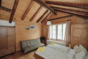 ein Schlafzimmer mit einem Bett und einem Sofa in der Unterkunft CityChalet historic in Interlaken