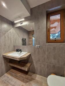 a bathroom with a sink and a mirror at Apartamenty Słodyczki in Nowe Bystre