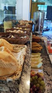 a buffet line with baskets of bread and fruit at Pousada Imperial Cidade in Ouro Preto