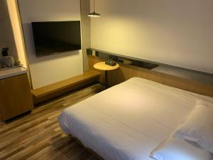 Postel nebo postele na pokoji v ubytování 银座佳驿精致酒店（济阳汽车总站店）