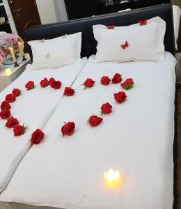 un groupe de roses sur un lit avec une bougie dans l'établissement Spa Mega Mall Monza National Arena, à Bucarest