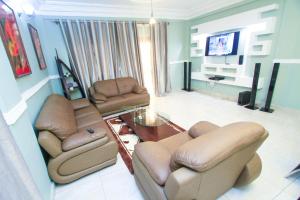 a living room with two couches and a television at Convivium Home Hotel in Douala