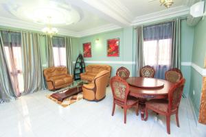 a living room with a wooden table and chairs at Convivium Home Hotel in Douala