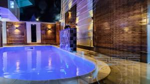 a hot tub in a room with a brick wall at Convivium Home Hotel in Douala