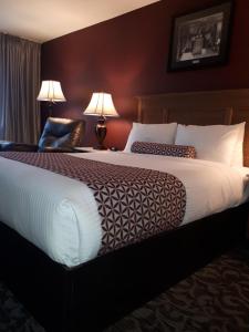 a hotel room with a bed and a lamp at Royal Anne Hotel in Kelowna