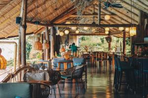 um restaurante com mesas e cadeiras e pessoas ao fundo em Finca Luna Nueva Lodge em Fortuna