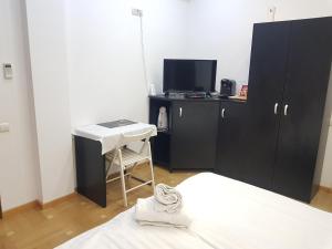 - une chambre avec un lit, un bureau et une télévision dans l'établissement Spa Mega Mall Monza National Arena, à Bucarest