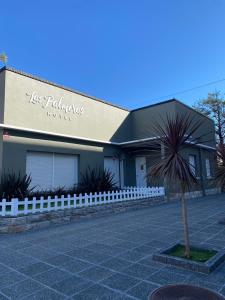 un bâtiment avec une clôture blanche devant lui dans l'établissement Las palmeras Hotel, à Miramar