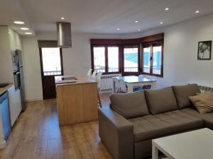 a living room with a couch and a kitchen at 102A Apartamento moderno 2 habitaciones in Gijón